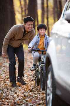 快乐的父亲保护儿子骑自行车