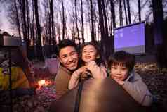 幸福的父亲和两个孩子夜晚野外露营三个人清晰摄影