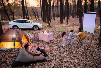 秋天傍晚幸福家庭在户外露营