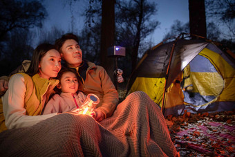幸福的一家三口夜晚在野外露营爱氛围相片
