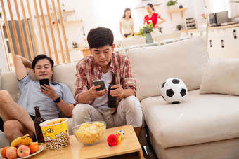 年轻朋友坐在沙发上看手机发短信高质量镜头