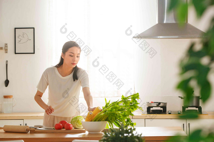 青年女人在厨房里做饭玉米高质量照片