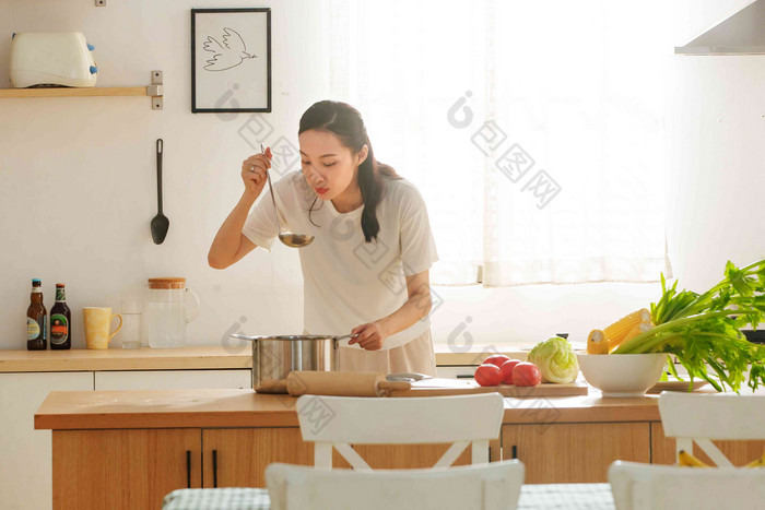 青年女人在厨房里做饭餐饮写实照片