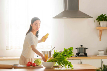 青年女人在厨房里做饭锅写实摄影图