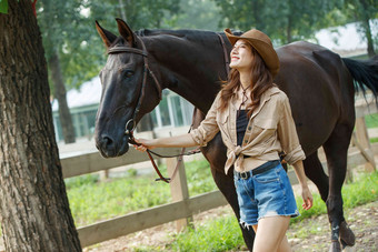 快乐的青年女人牵着马