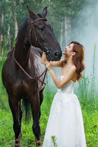 户外穿裙子的漂亮年轻<strong>女人</strong>和马