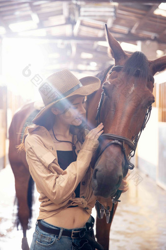 马厩走廊里的青年女人抚摸<strong>骏马</strong>