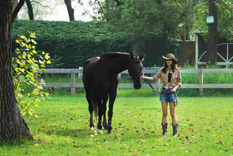 户外草地上青年女人牵着马快乐氛围图片