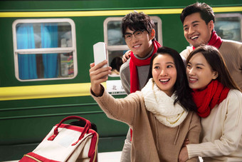 青年男女在火车站台上用手机旅行者写实镜头