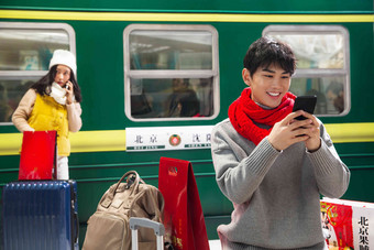 在火车站台上看手机的青年男人旅途高质量拍摄