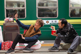 两名男子在火车月台上看手机白昼清晰镜头