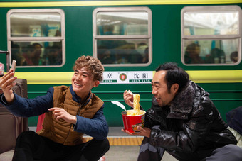 两名男子在火车月台上看手机休闲装高清拍摄