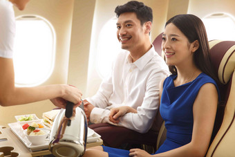 年轻夫妇在飞机上用餐窗户高质量场景