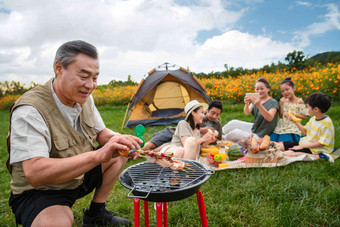 快乐家庭在郊外烧烤野餐生态旅游写实摄影图