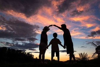 夕阳下幸福的<strong>一家</strong>三<strong>口</strong>手牵手户外清晰素材