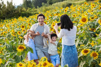 幸福家庭在<strong>花海</strong>里照相臂挽臂素材