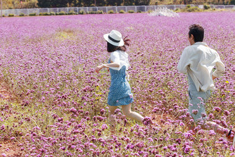 在<strong>花</strong>海里奔跑的青年夫妇