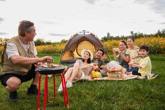 快乐家庭在郊外烧烤野餐