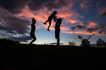 夕阳下幸福的<strong>一家</strong>三口成年人氛围摄影图