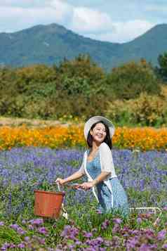 推着自行车的青年女人站在花海里