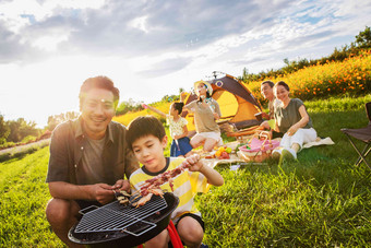 欢乐的一家人在郊外野餐烧烤人照片