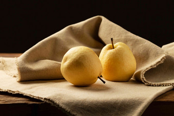 两个梨放在桌子上食物氛围照片