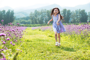 快乐的小女孩在花海里奔跑户外高端摄影图