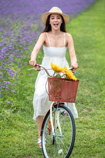 青年女人在花海里骑<strong>自行车田园</strong>风光氛围素材
