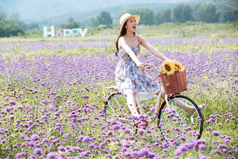 青年女人在花海里骑自行车放松拍摄