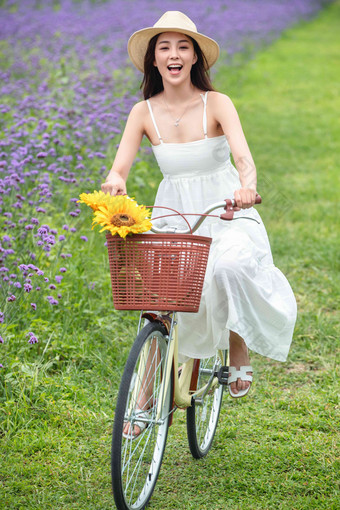 青年女人在花海里骑自行车草地清晰场景