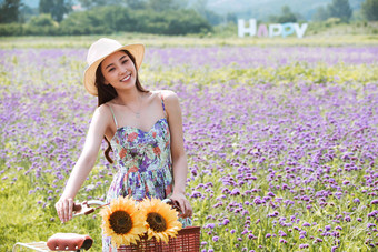 青年女人在花海里骑自行车田园风光高质量图片