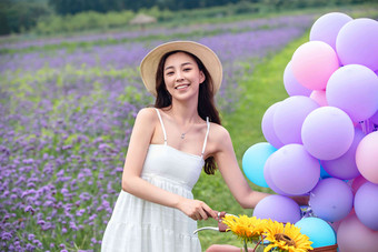 青年女人在花海里骑自行车花海写实拍摄