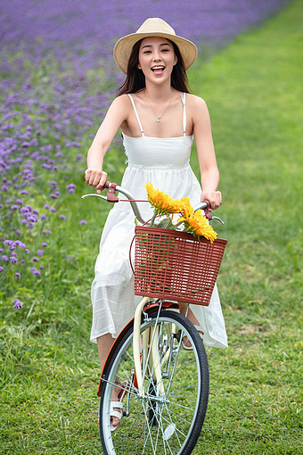 青年女人在花海里骑自行车