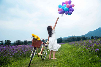 青年女人在花海里拿着气球薰衣草氛围拍摄