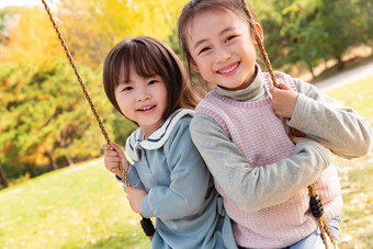 两个女孩在公园里荡秋千