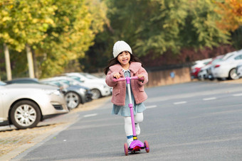 快乐的小女孩在户外玩<strong>滑板车</strong>