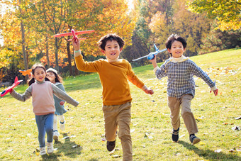 快乐儿童拿着玩具飞机在公园玩耍活力氛围素材