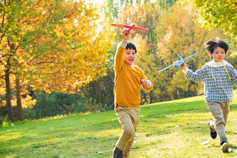 拿着玩具飞机在公园玩耍的<strong>快乐</strong>儿童