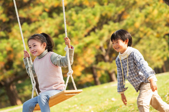 在公园里荡秋千的快乐儿童水平构图高质量照片