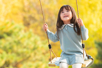 在公园里荡秋千的快乐女孩彩色图片高端场景