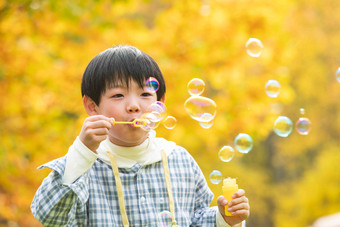 可爱的小男孩在公园里吹泡泡