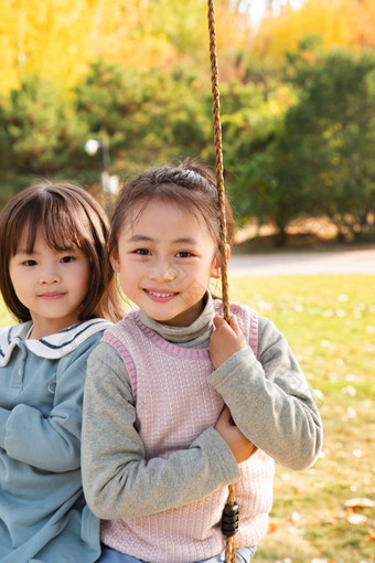 两个女孩在公园里<strong>荡秋千</strong>兴奋氛围图片