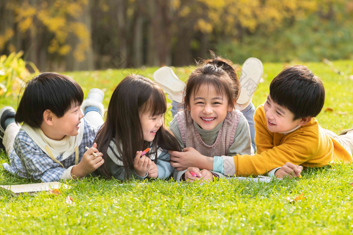 可爱的小朋友们趴草地上玩耍小学生写实素材