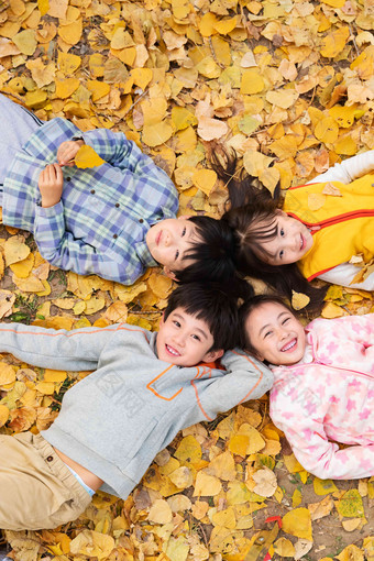 可爱的小朋友们躺在落叶上玩耍
