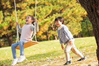 快乐儿童在公园里荡秋千人相片