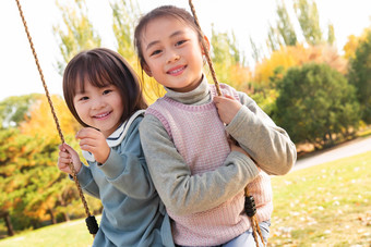 两个女孩在公园里荡秋千