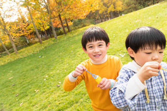 快乐的男孩在公园里吹泡泡