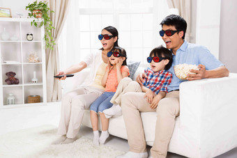 东方家庭戴着3D眼镜坐在沙发上