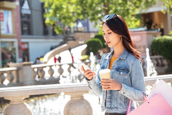 青年女人拿着手机逛街户外清晰素材