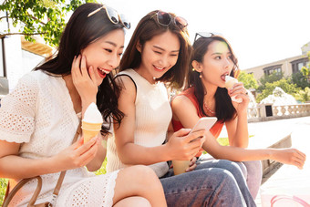吃<strong>冰淇淋</strong>的青年闺蜜看手机青年女人高清影相